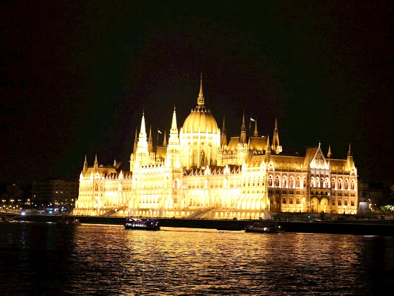 La facciata illuminata del Parlamento di Budapest sul Danubio