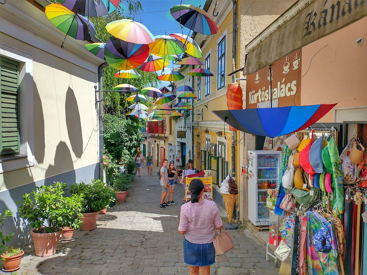 Un vicolo di Santandrea con botteghe di artigiani e ombrelli colorati